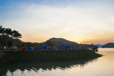 Tents in camping site at lake side at sunsetの写真素材