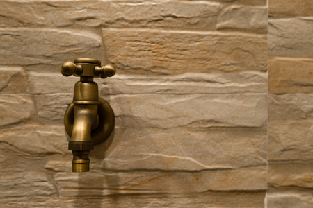 Brass water valve on the wall in bathroomの写真素材