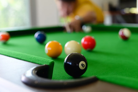 Young man playing pool in a bar.focus on the ball