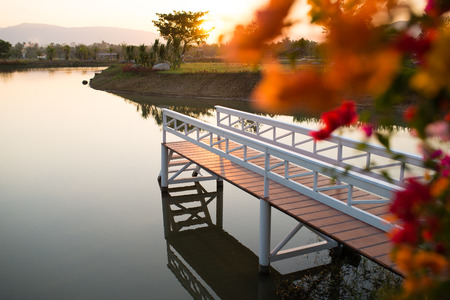 Beautiful white bridge on lake sunrise Thailandの写真素材