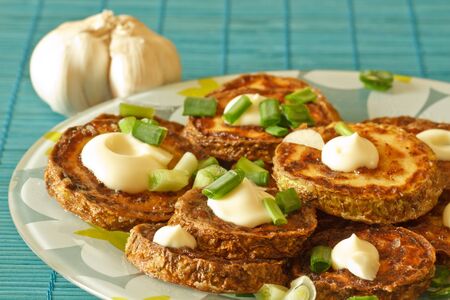 fried zucchini with garlic closeup on a plateの写真素材