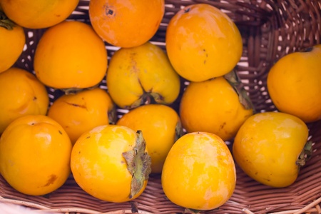 ripe persimmons in a basket close upの写真素材