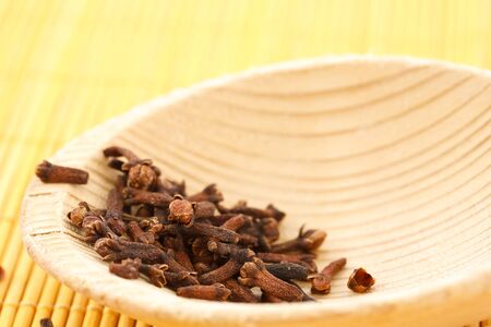 Dried cloves on a wooden spoonの写真素材