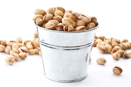 pistachio nuts in a bucket on a white backgroundの写真素材