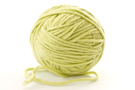 ball of green woolen threads on a white background