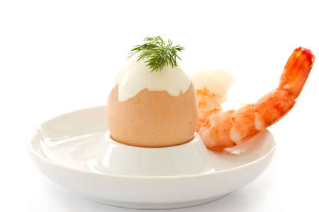 boiled egg and boiled shrimp on a big white backgroundの写真素材