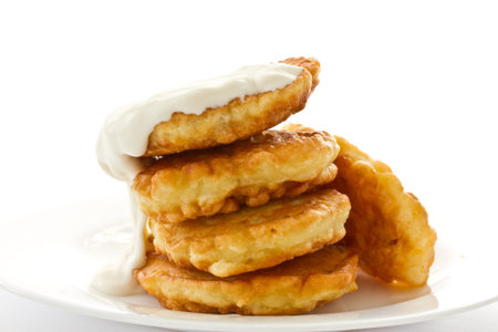 fried fritters on a white plate on white background