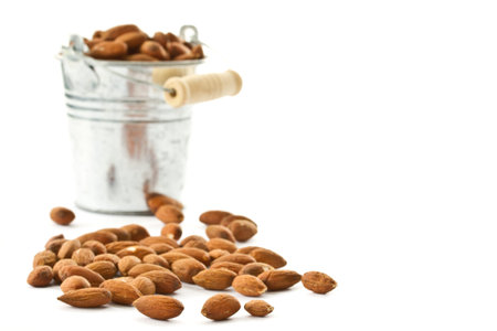almonds in a bucket on a white backgroundの写真素材