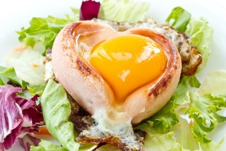 scrambled eggs with sausage on a heart-shaped leaves of lettuceの写真素材