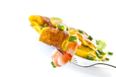 omelet with cooked shrimp and greens on a white backgroundの写真素材