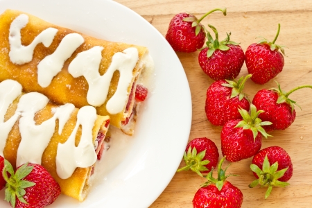 Pancakes with strawberries and cream on a plateの写真素材