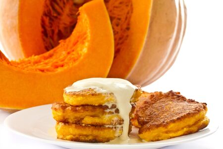 pumpkin pancakes with sour cream on a background of ripe pumpkinsの写真素材