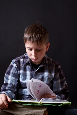 boy with a book on a black backgroundの写真素材
