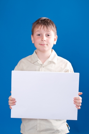 boy holding a blank form on a blue backgroundの写真素材