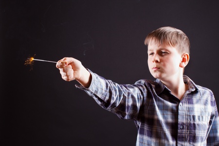 portrait of a boy with sparklers on black backgroundの写真素材