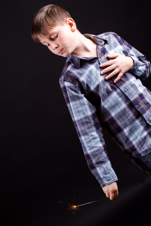 portrait of a boy with sparklers on black backgroundの写真素材