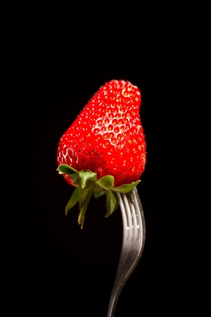 ripe red strawberries on a black backgroundの写真素材
