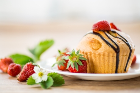 strawberry muffins with chocolate sauce on a white plateの写真素材