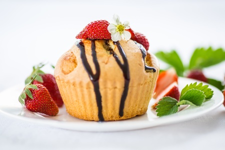 strawberry muffins with chocolate sauce on a white plateの写真素材
