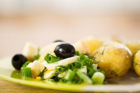 green salad with onion and squid with boiled potatoesの写真素材