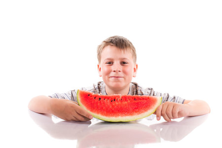 happy boy with ripe watermelon on a white backgroundの写真素材