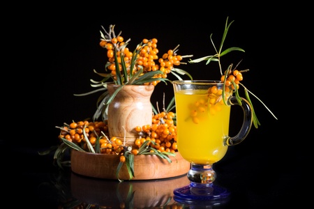 sea buckthorn tea in a cup on a black backgroundの写真素材
