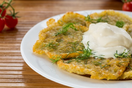 potato pancakes with sour cream and dillの写真素材