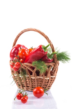 ripe tomatoes and red pepper basket on a white backgroundの写真素材
