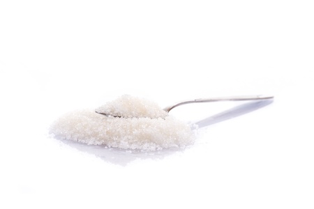 granulated sugar in a spoon on a white backgroundの写真素材