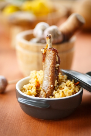 pilaf with rice and meat in a bowl on a wooden tableの写真素材