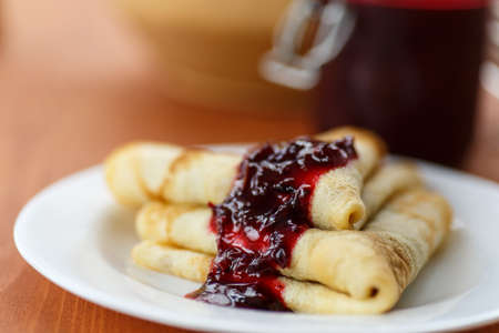 serving of pancakes with jam on a plateの写真素材