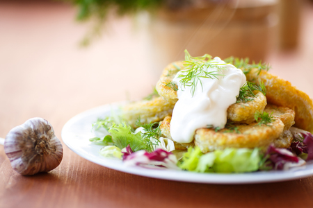 fried potato pancakes with lettuce leaves on a plateの写真素材