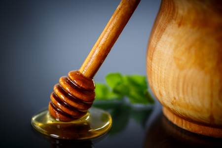 fresh liquid honey with a honey spoon on a black backgroundの写真素材