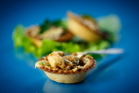 baked tartlets with mushrooms and cheese on a blue backgroundの写真素材