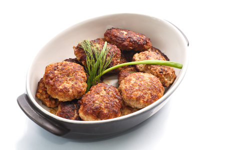 fried meatballs with herbs on white background