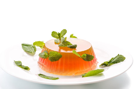 fruit jelly with mint on a plate on white background