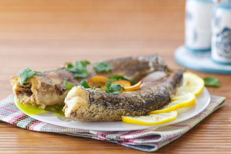Whole baked fish on a plate with lemon