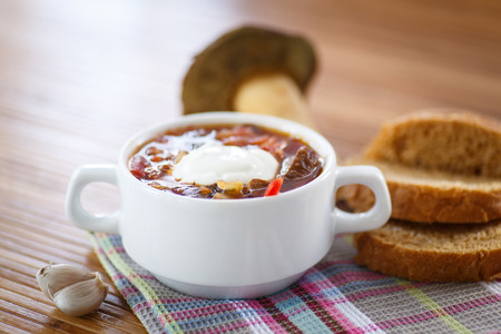 soup with mushrooms in a bowl on a wooden tableの写真素材