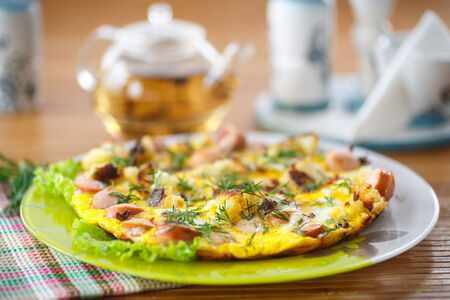 scrambled eggs and sausages cauliflower with dill on a wooden tableの写真素材