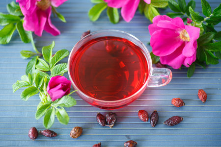 rosehip tea with fruits and flowers in a teapot on the tableの写真素材