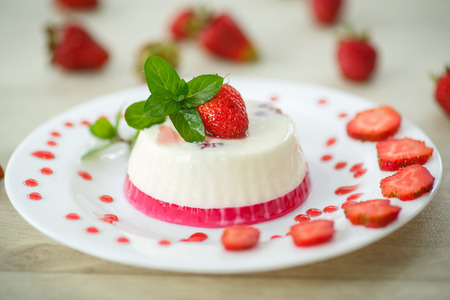 milk with strawberry jelly in glasses on a wooden tableの写真素材