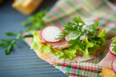 sandwich with lettuce, ham and radish for breakfastの写真素材