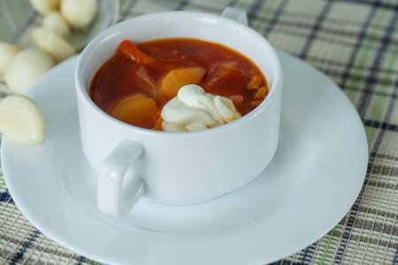 vegetable soup with beetroot in a bowl with sour cream and garlic