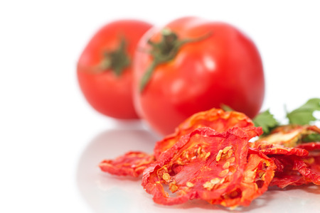 dried and fresh tomatoes on white backgroundの写真素材