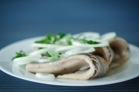 salted herring with onions on the tableの写真素材