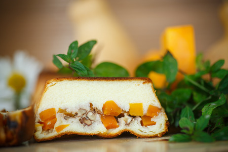 Cottage cheese casserole with slices of pumpkin and nuts on a dark wooden backgroundの写真素材
