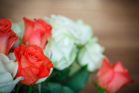 bouquet of red and yellow roses on a wooden dark backgroundの写真素材