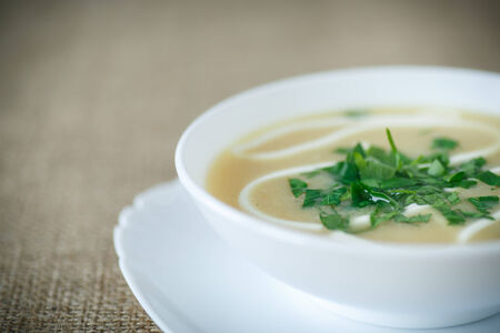 puree soup with greens and sour cream in a white plateの写真素材