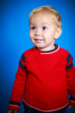 Portrait of a cute boy on the blue backgroundの写真素材