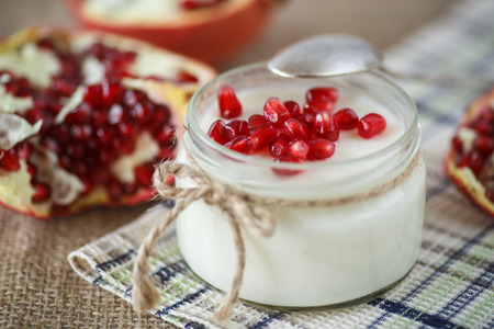 sweet homemade yogurt with berries pomegranate in a glass jarの写真素材